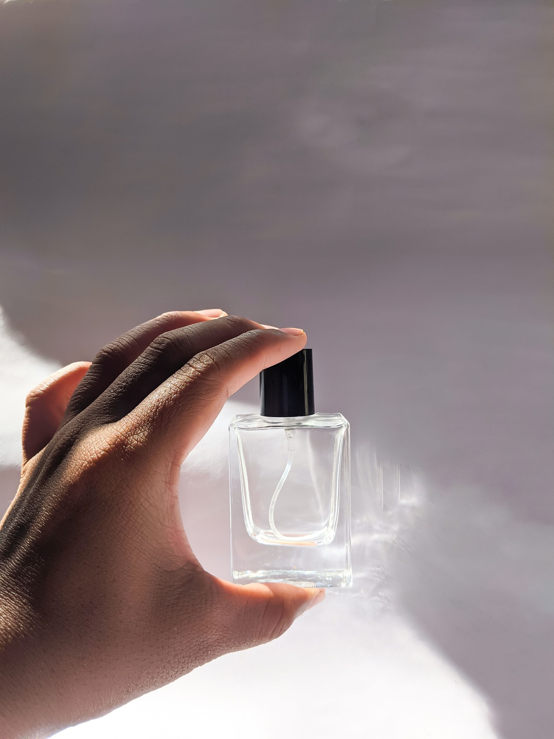 Hand holding a perfume bottle